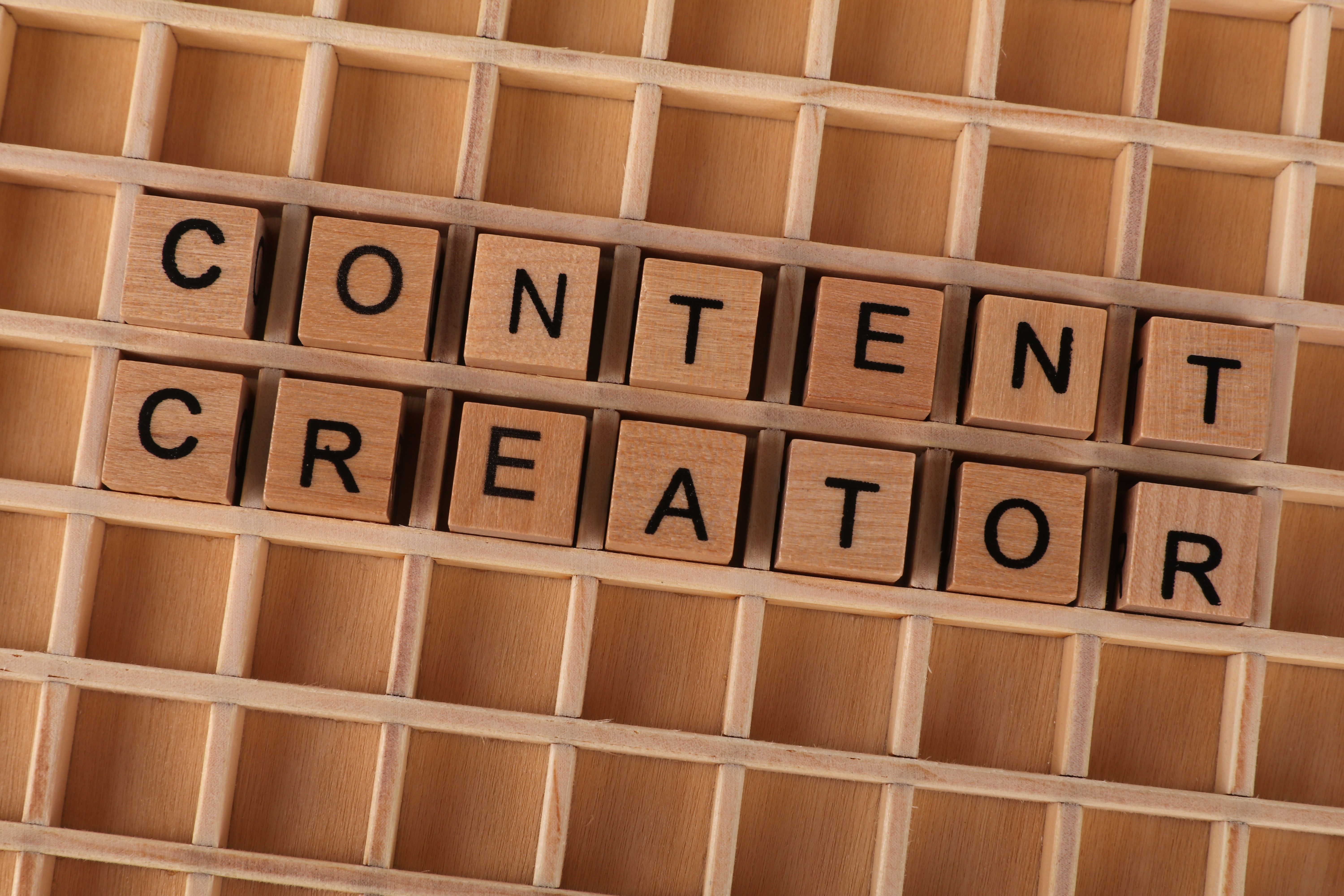 Wooden block letters spelling Content Creator on a grid background for a quality content blog